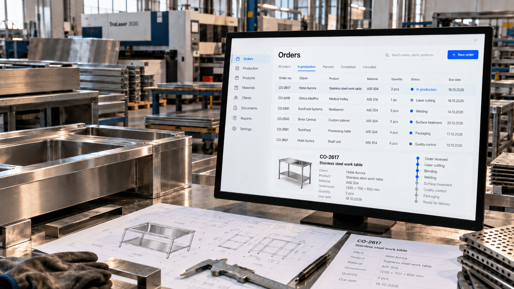 A stainless steel fabrication workshop: fabricated steel components and a technical drawing on the worktable, laser cutting machinery behind, and a monitor showing a production management interface listing current orders and their production stages.